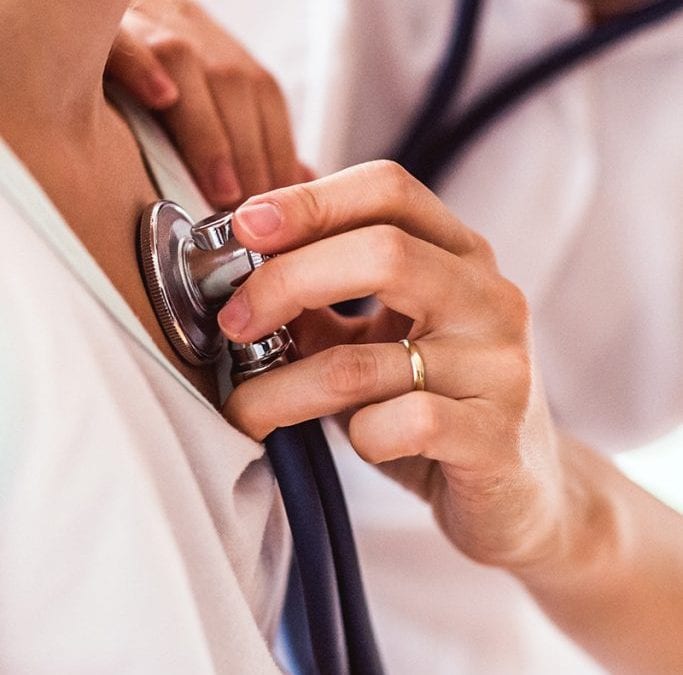 Stopwatch Urgent Care doctor checking patient with stethoscope